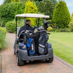senior male golfer riding golf buggy